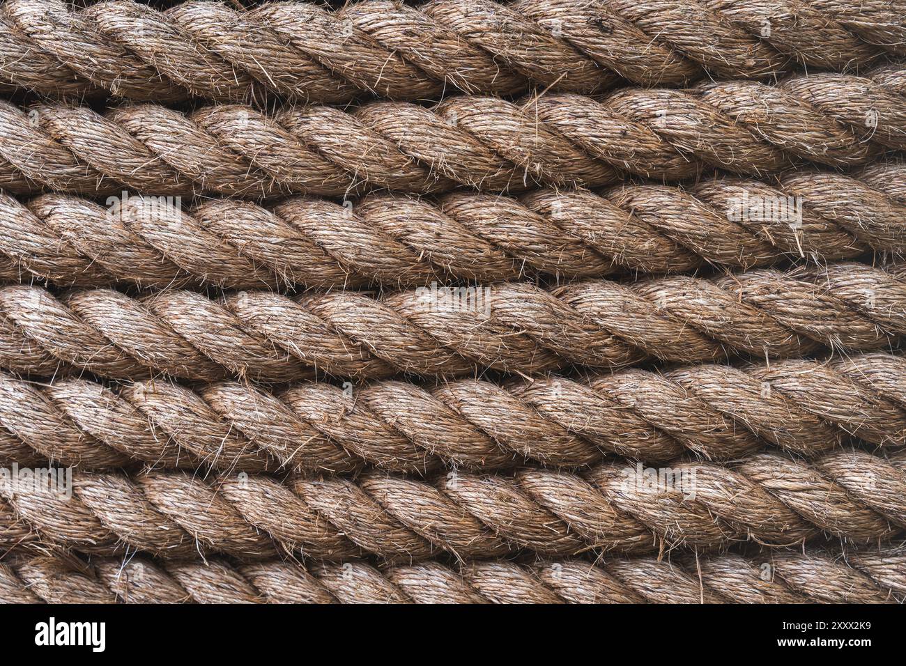 Uno sfondo full frame di spessa fune di spedizione strettamente avvolta insieme e realizzate in fibre naturali durevoli come la iuta con spazio di copia Foto Stock