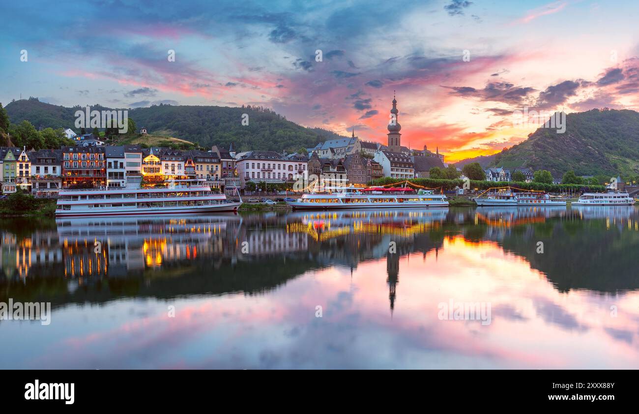 Vista al tramonto di Cochem con la Chiesa di San Martino, edifici colorati e riflessi, Germania Foto Stock