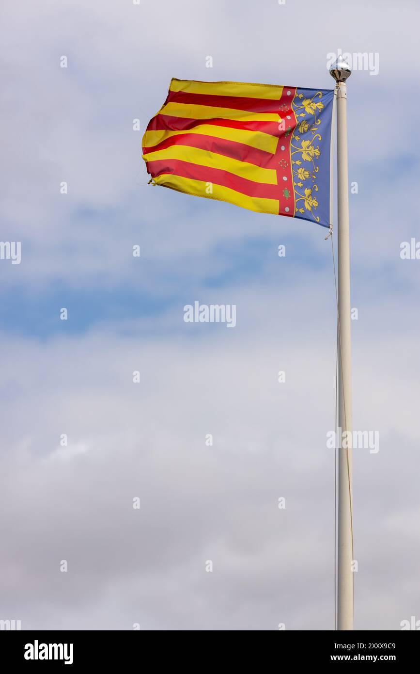 Foto della bandiera della Comunità Valenciana che sventolava nel vento in una giornata limpida. La Comunità Valenciana è una comunità autonoma della Spagna Foto Stock