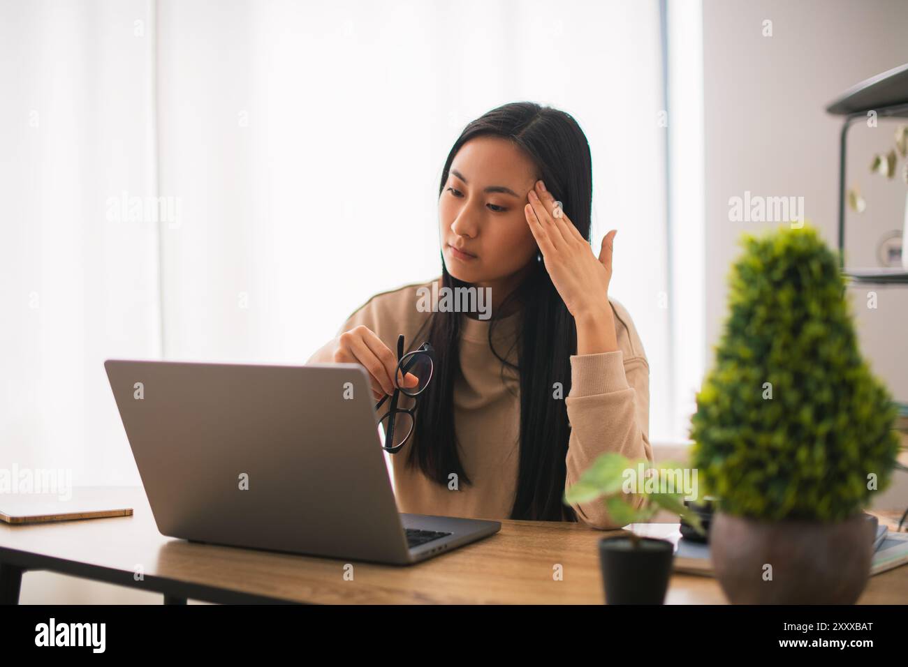 Stanco giovane asiatico coreano donna lavoratore studente fare una breve pausa in lavoro online rimuovere occhiali massaggio dipendente femminile sovraccaricato da laptop Foto Stock