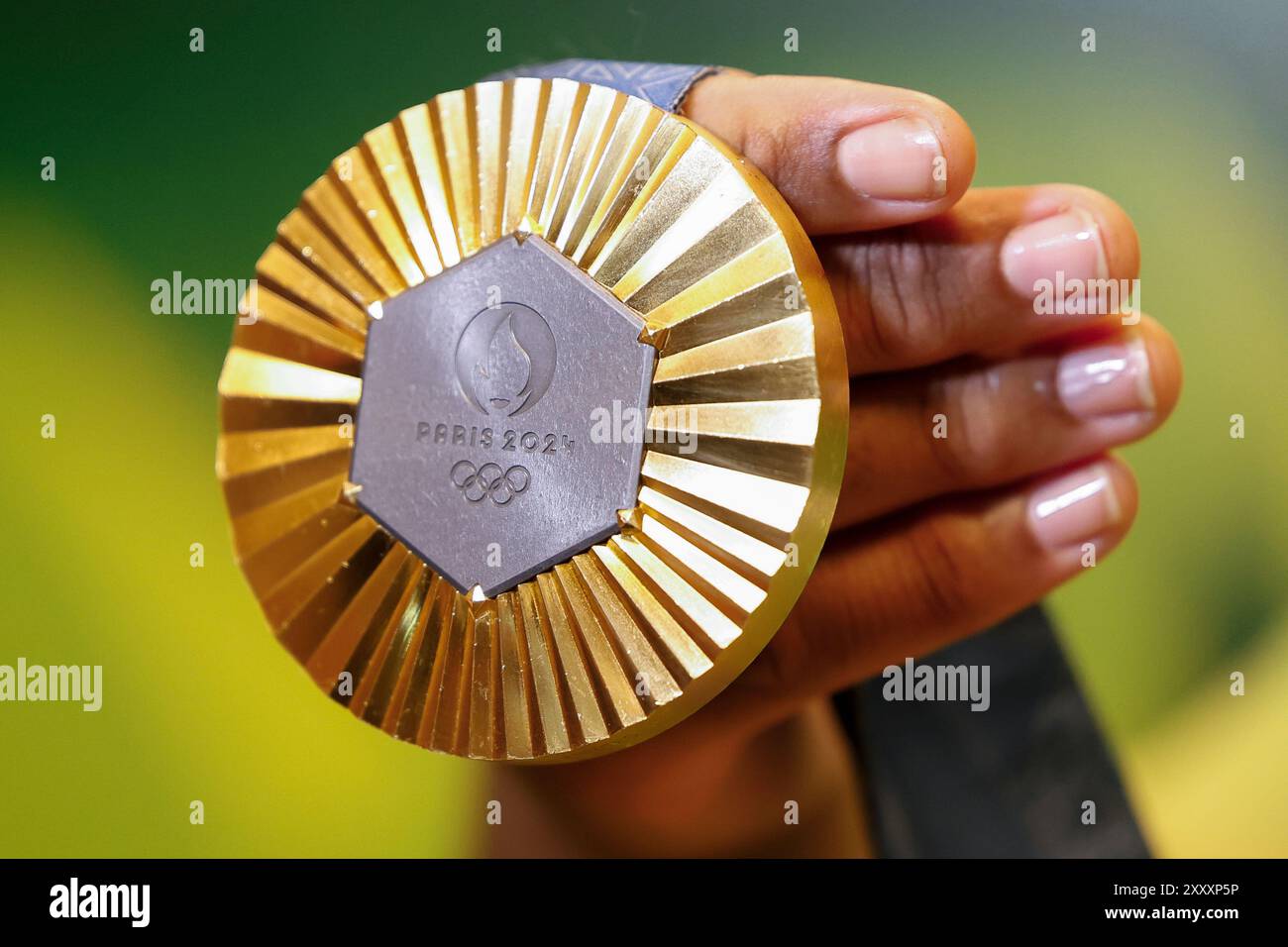 Medaglia d'oro ai Giochi Olimpici di Parigi 2024 ripresa con dettaglio portatile, simbolo del vincitore delle competizioni sportive. Foto Stock