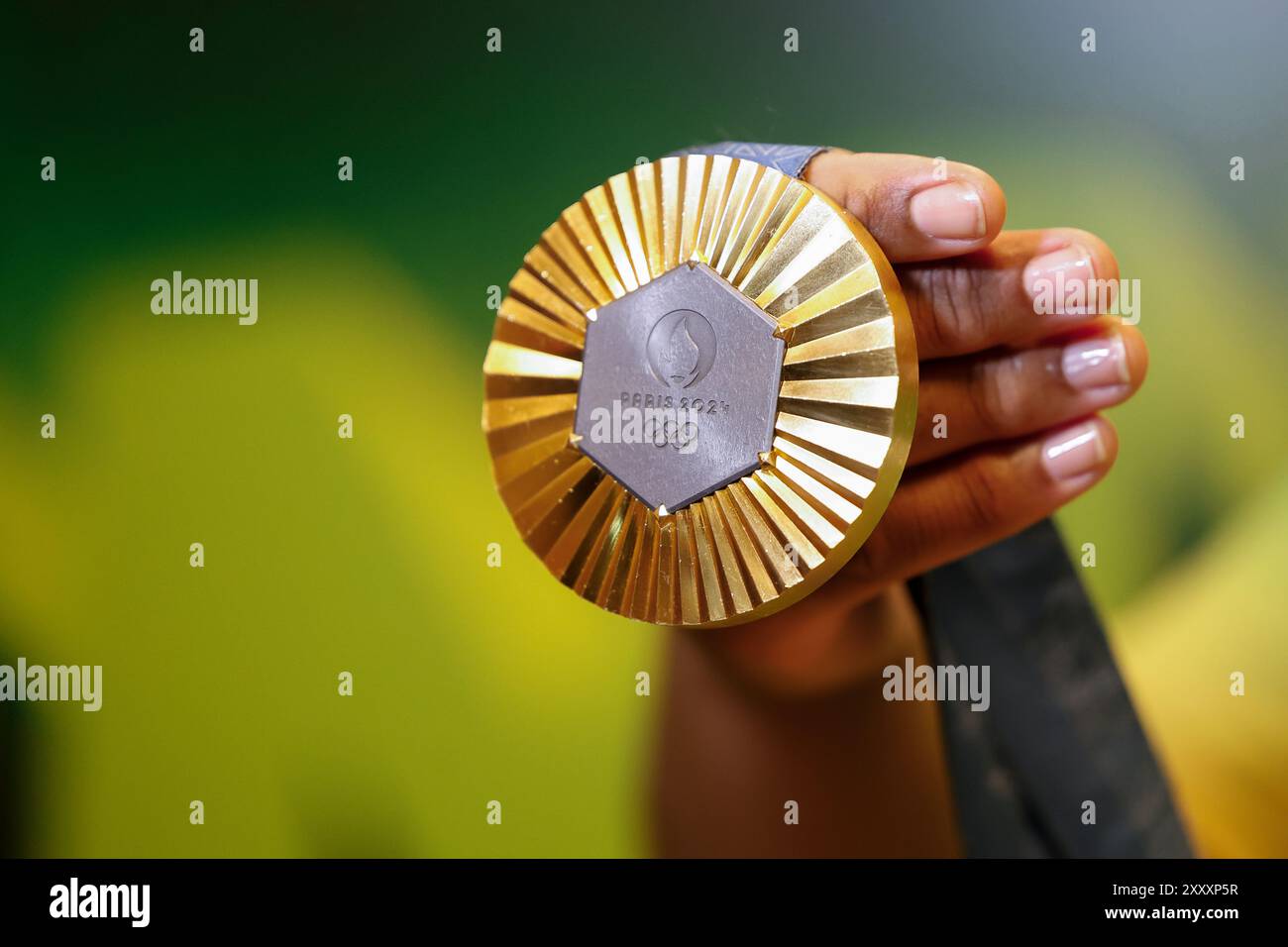 Medaglia d'oro ai Giochi Olimpici di Parigi 2024 ripresa con dettaglio portatile, simbolo del vincitore delle competizioni sportive. Foto Stock