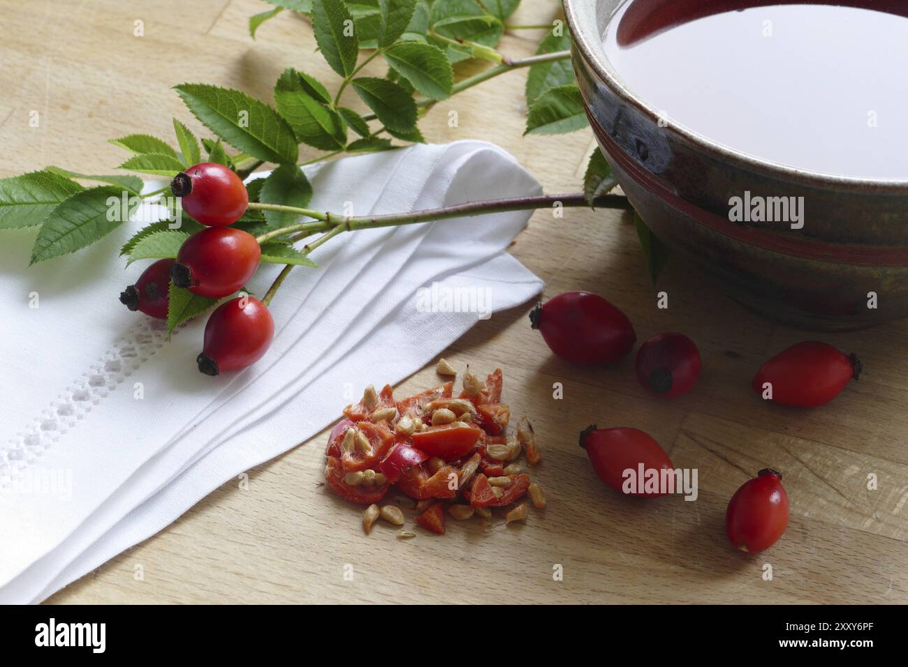 Rosa fianchi appena affettati e rosa hip tea con un sacco di vitamina c in una tazza di ceramica per rafforzare il sistema immunitario Foto Stock