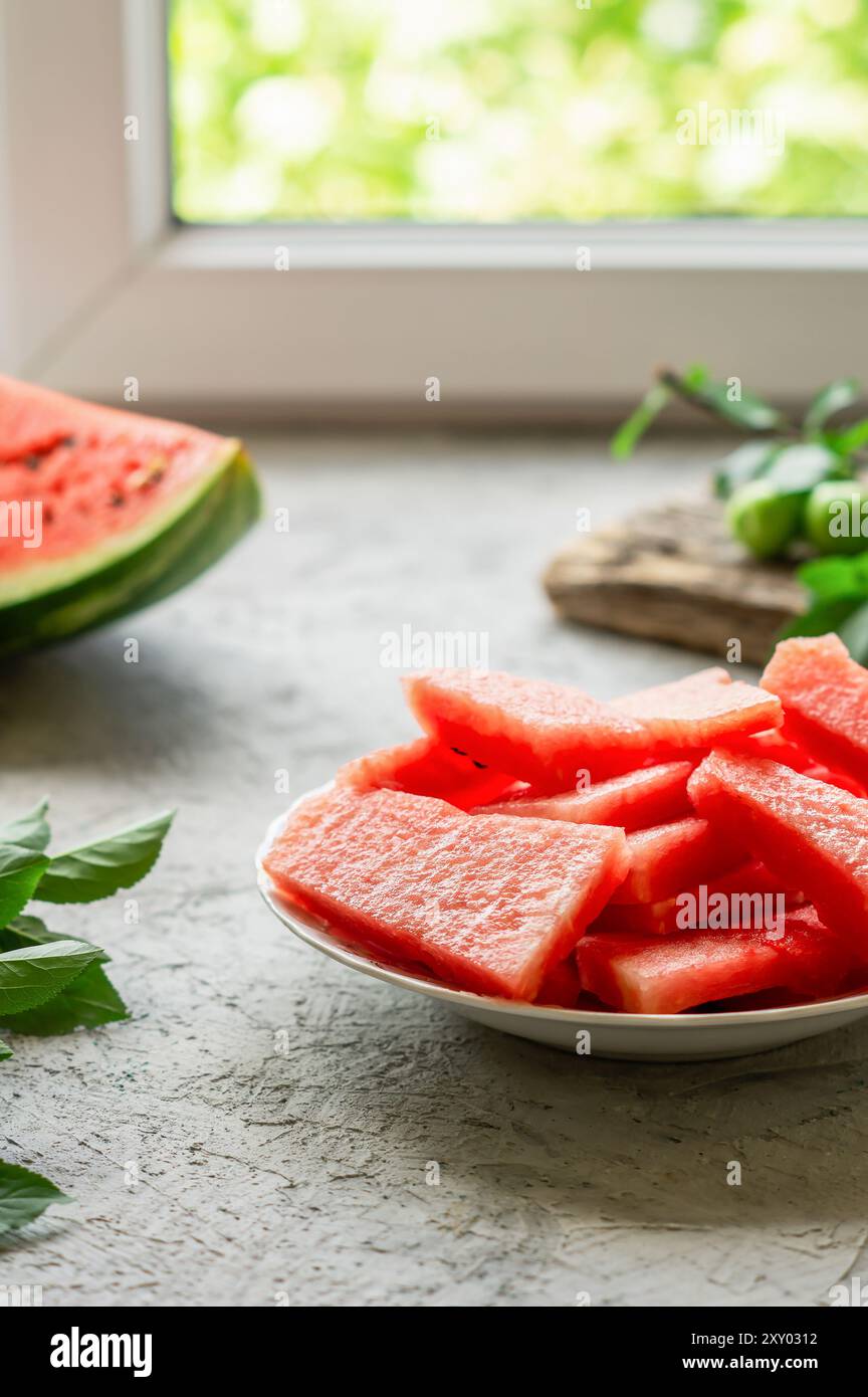 Fetta di anguria fresca nel piatto su fondo di pietra bianca Foto Stock