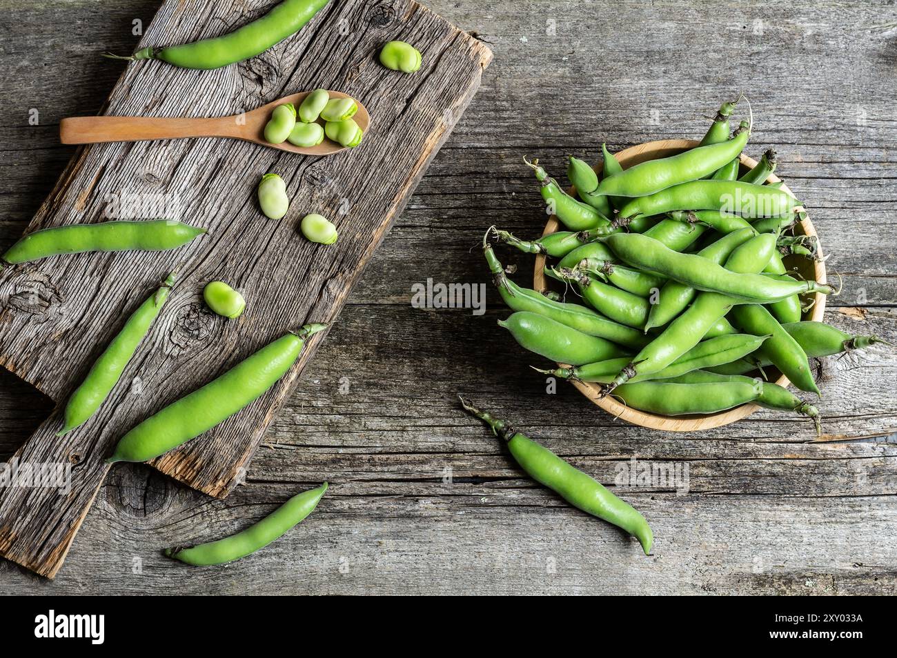 Fave fresche con baccello su fondo rustico, cibo sano Foto Stock
