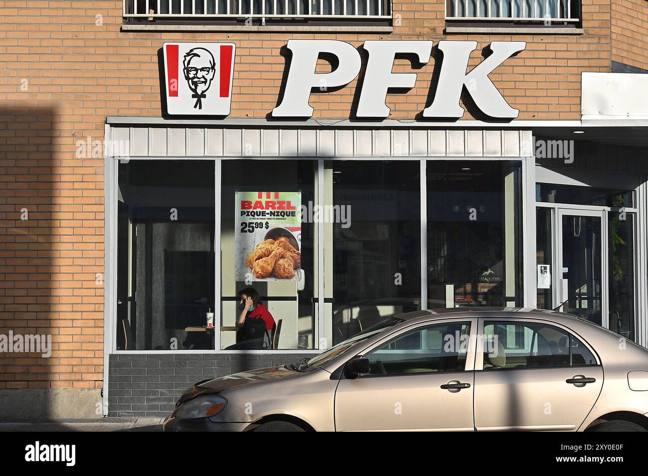 Canada, Quebec, Montreal: Fast food PFK. Uomo seduto a un tavolo. Per controllare il declino della lingua francese, le imprese nelle pr canadesi Foto Stock