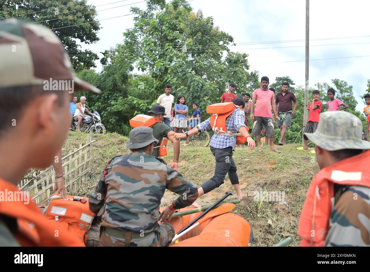 Il personale di Assam Rifles va in un campo di soccorso attraverso l'acqua inondata per distribuire cibo alle vittime delle inondazioni nei campi di soccorso della città di Amarpur, a 82 km da Agartala. Tripura, India. Foto Stock