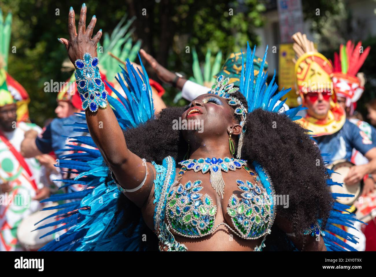 Ballerina nera che si esibisce alla Grand Parade di Carnevale di Notting Hill 2024. Giornata degli adulti il lunedì festivo. Indossa un elaborato costume di piume Foto Stock