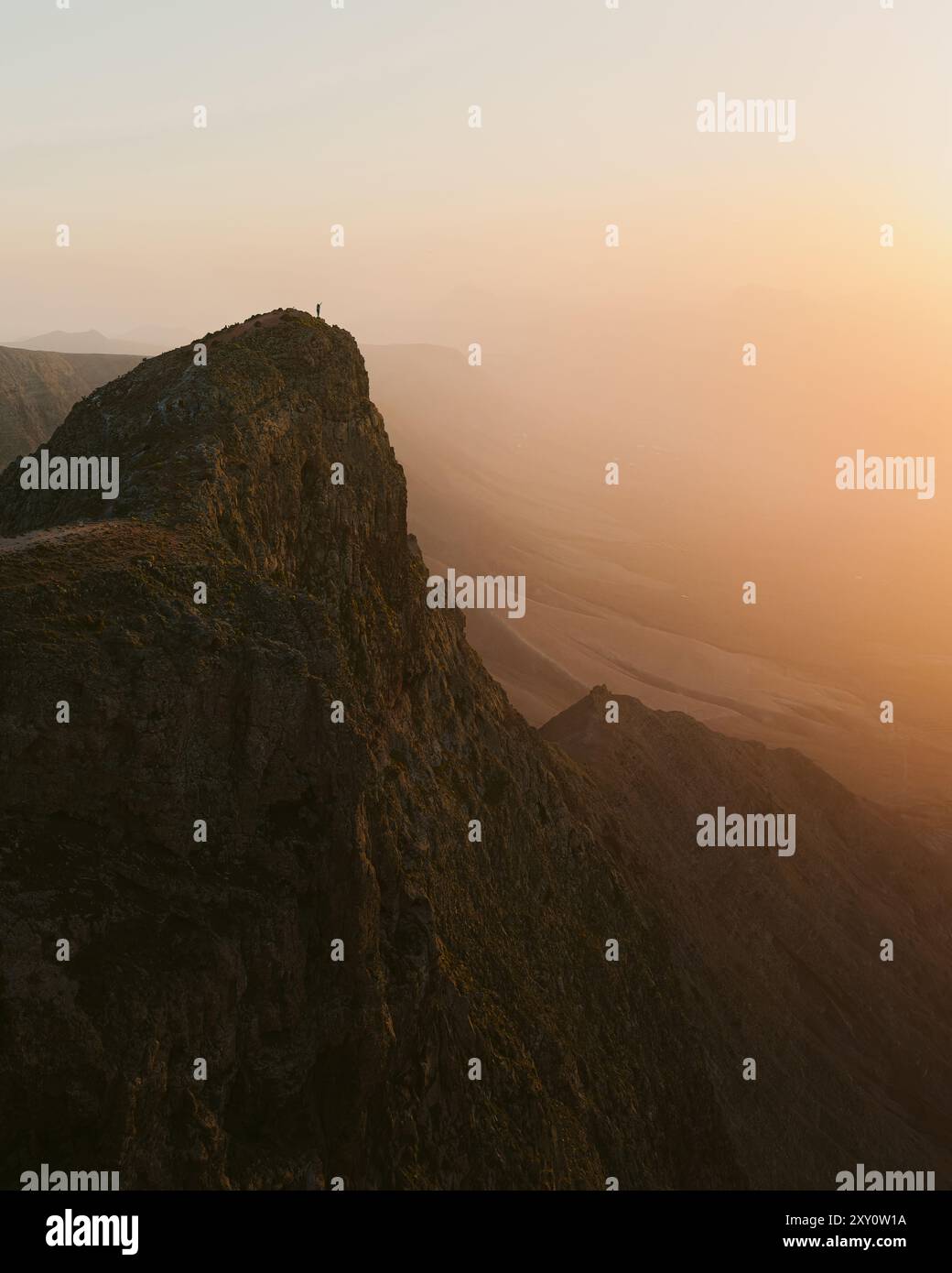 Una maestosa vista del tramonto a Lanzarote, che mostra il vasto paesaggio vulcanico sotto un cielo caldo e luminoso Foto Stock