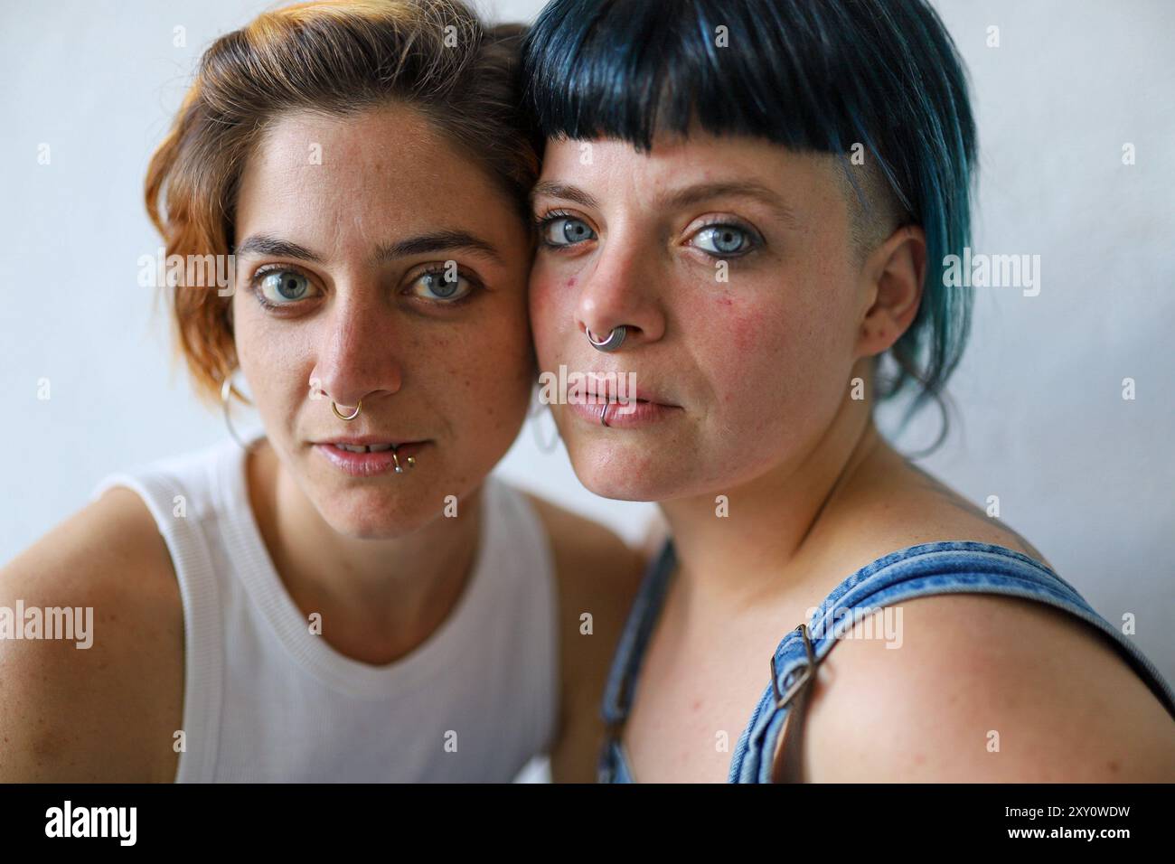 Ritratto ravvicinato di due sorelle adulte con caratteristiche fisiche uniche come piercing e vari colori dei capelli. Entrambi guardano la telecamera, che CA Foto Stock