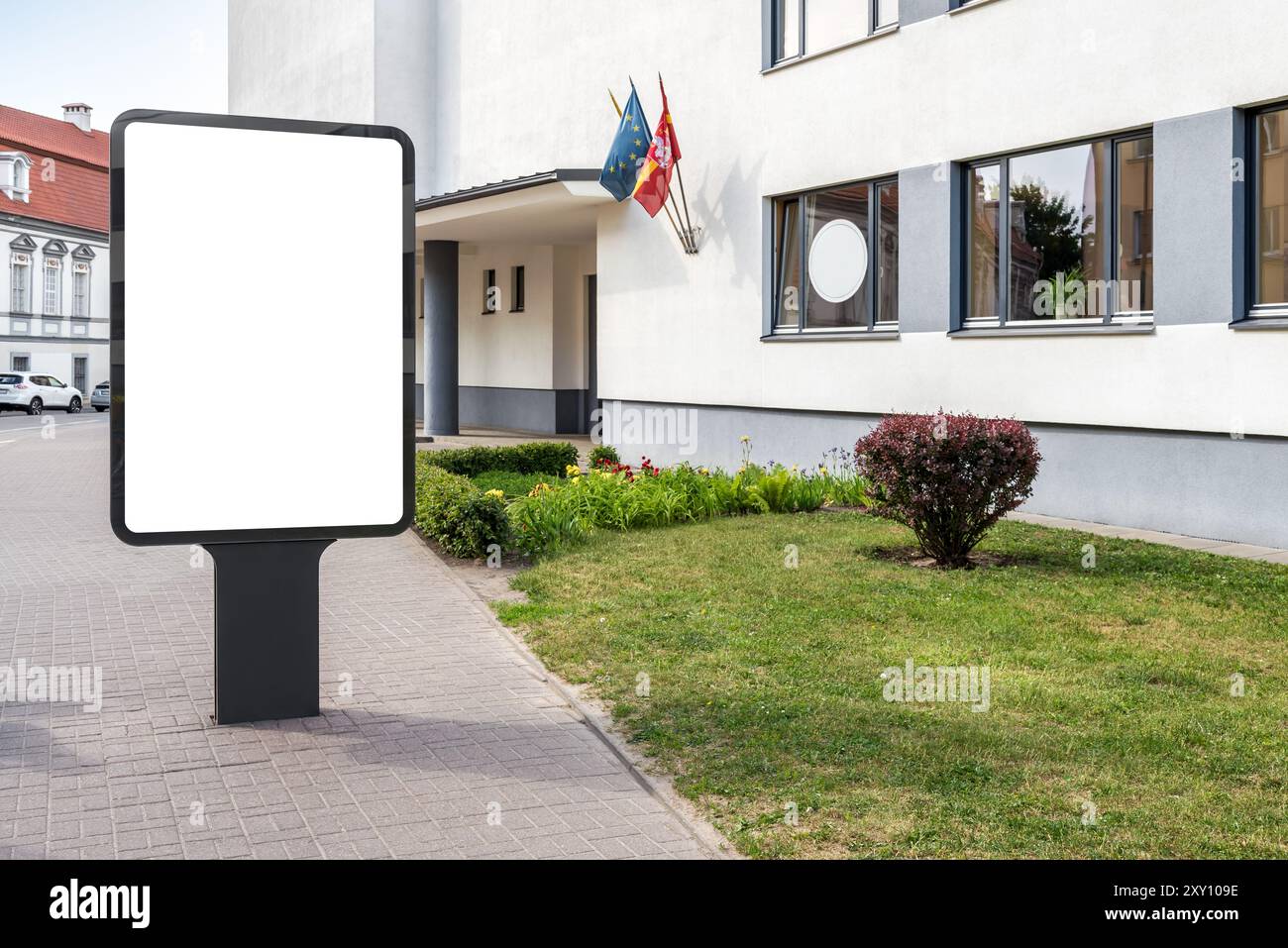 Mockup vuoto di Vertical Street Billboard sul marciapiede. Poster pubblicitario Lightbox accanto alla scuola superiore Foto Stock