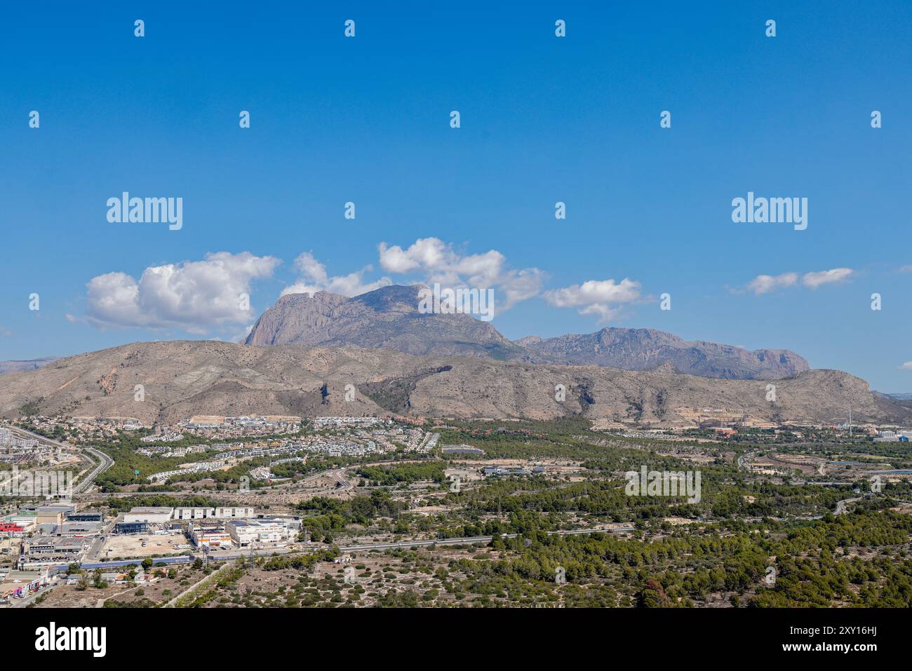 Foto aerea con drone della bellissima città di Benidorm in Spagna che mostra il lato sud della città con le alte montagne sullo sfondo su un sole Foto Stock