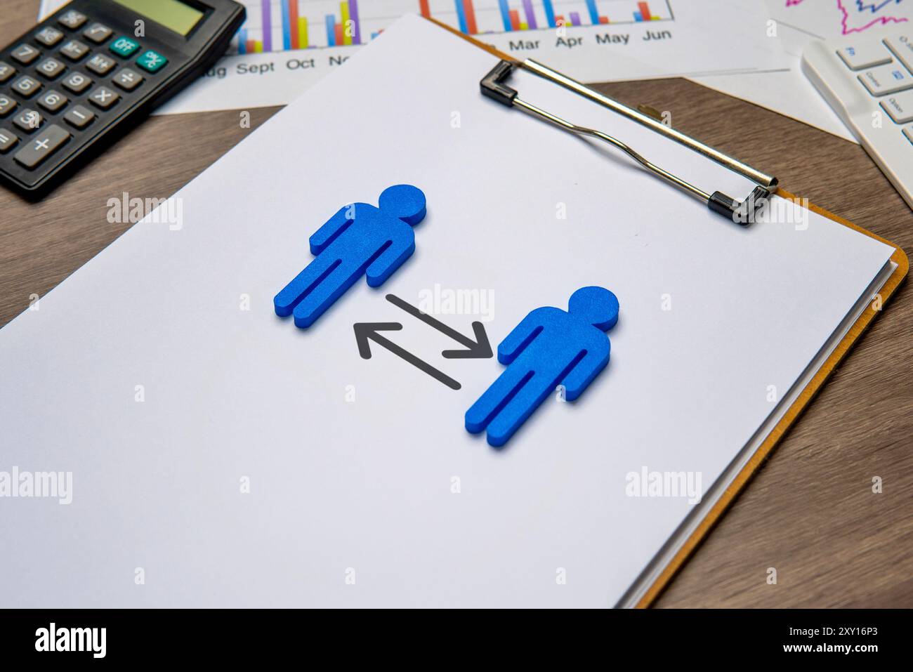 Due figure blu su una clipboard, rivolte l'una verso l'altra con frecce che puntano in entrambe le direzioni. Ciò simboleggia il concetto di rotazione del lavoro. Foto Stock