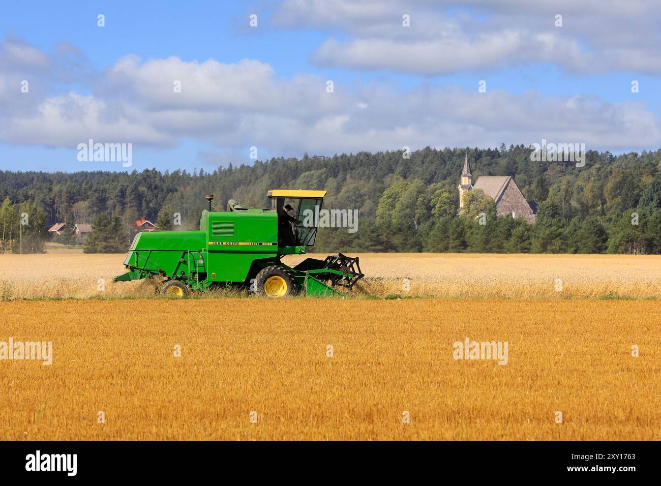 L'agricoltore raccoglie grano maturo con la mietitrebbia John Deere 1042 in una giornata di sole all'inizio dell'autunno. Copia spazio. Salo, Finlandia. 25 agosto 2024. Foto Stock