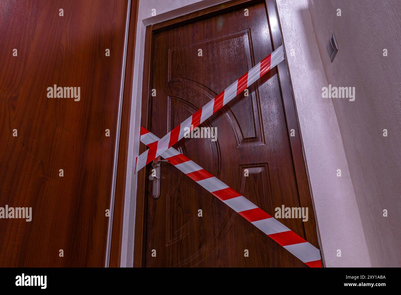 La porta d'ingresso dell'appartamento, il nastro della polizia, ha messo in sicurezza la scena del crimine, ha fatto irruzione nell'appartamento Foto Stock