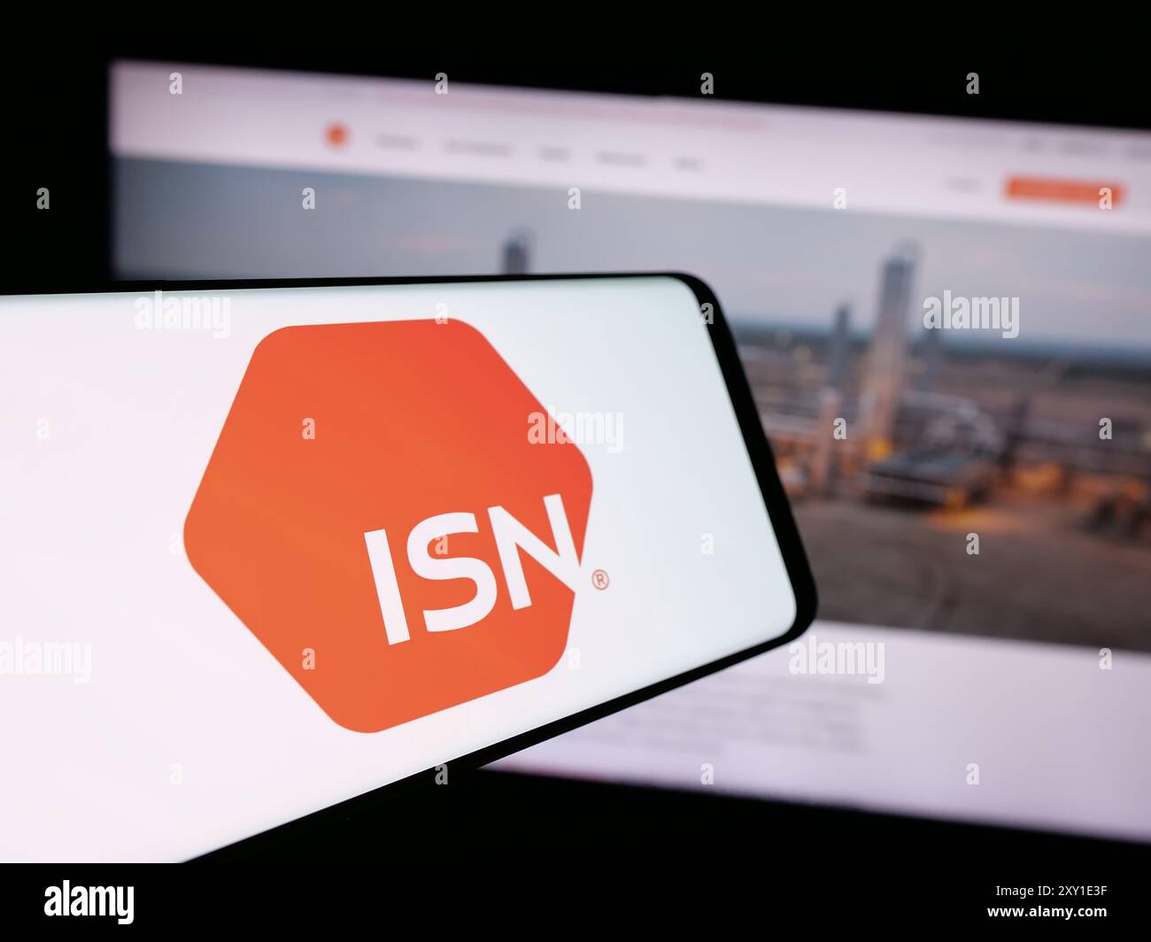 Telefono cellulare con logo del software contrattuale americano ISN software Corporation davanti al sito web. Mettere a fuoco la parte centrale sinistra del display del telefono. Foto Stock