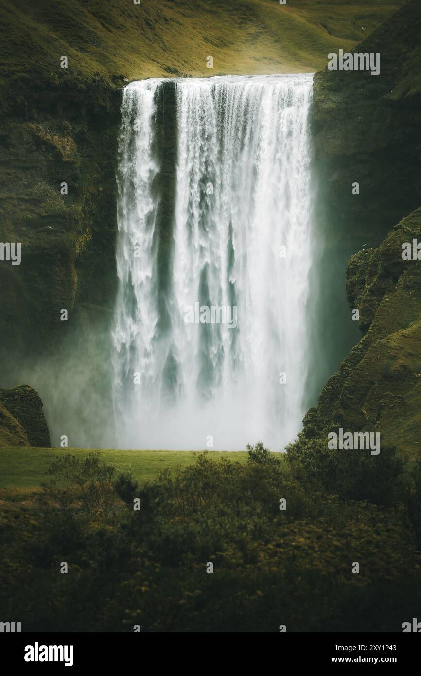 La splendida cascata di Skogafoss, vista da una prospettiva diversa in una giornata piovosa, potente cascata, destinazione turistica Foto Stock