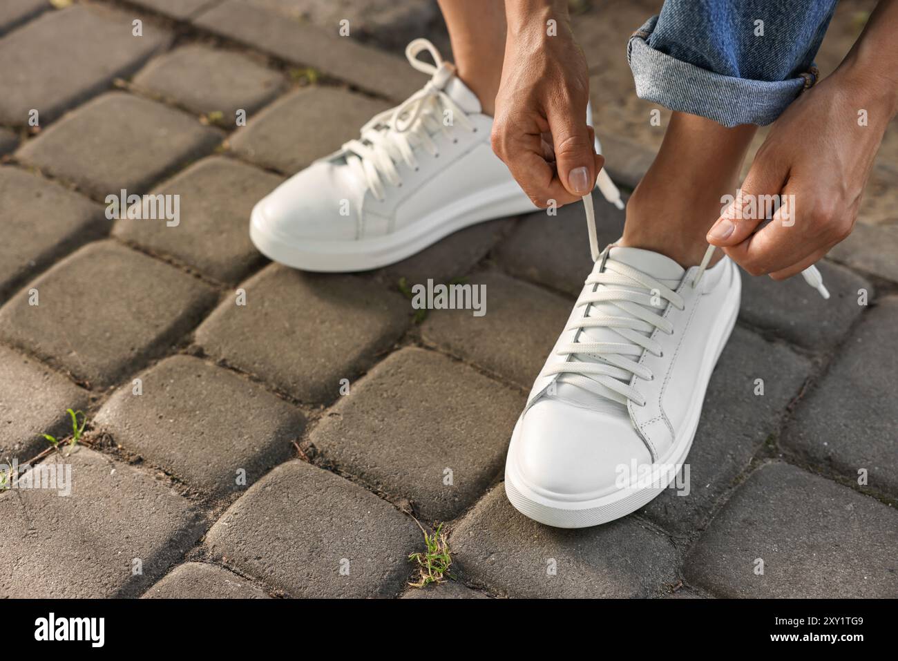 Donna con lacci di scarpe bianche all'aperto, primo piano Foto Stock