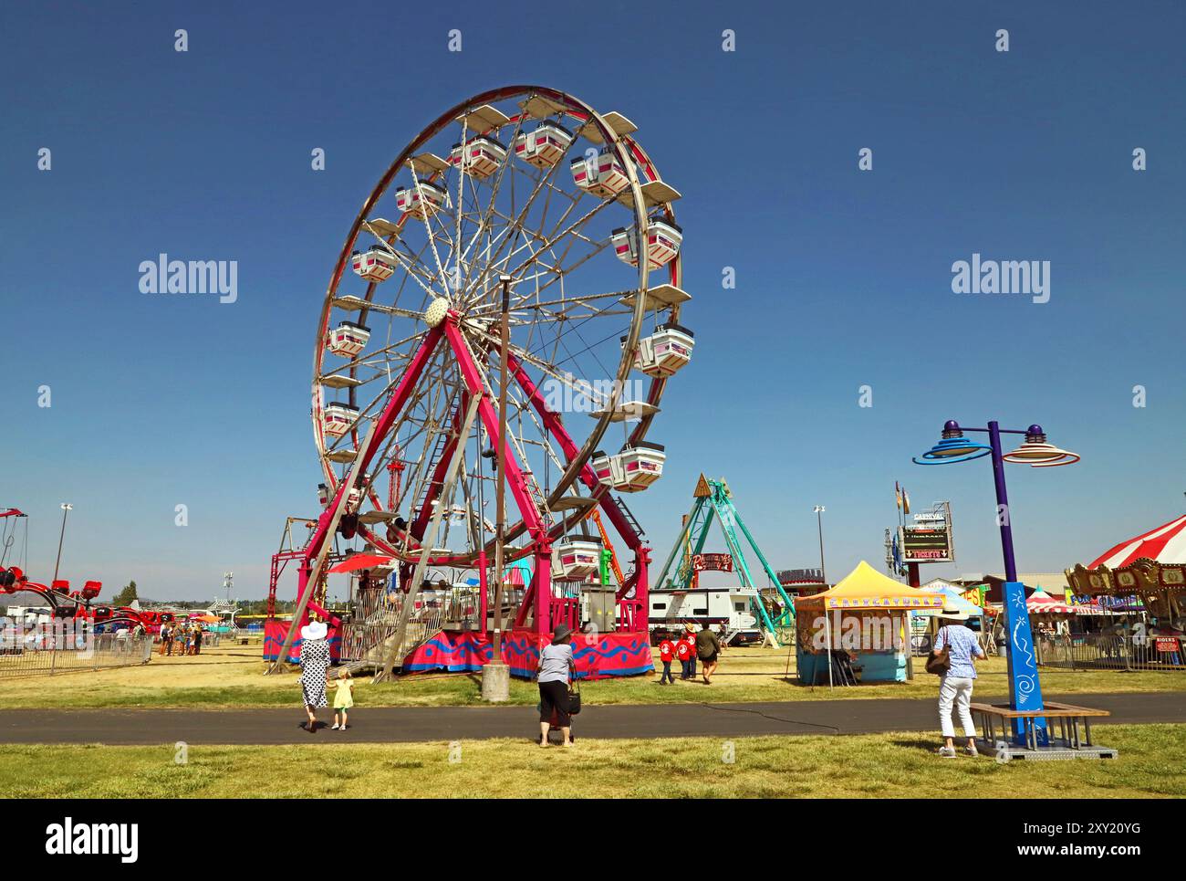 Giostre di carnevale e venditori di cibo punteggiano i terreni e a metà strada della fiera della contea di Deschutes del 2024 a Redmond, Oregon. Foto Stock