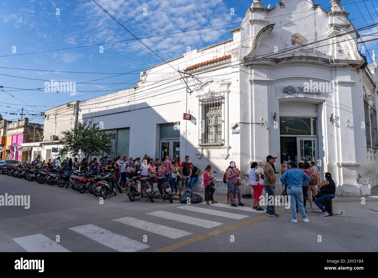 I clienti aspettano in fila fuori da una banca a Monteros, provincia di Tucumán, Argentina. Foto Stock