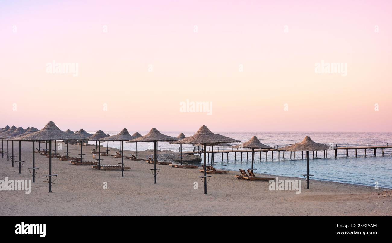 Foto di una spiaggia vuota al tramonto viola. Foto Stock