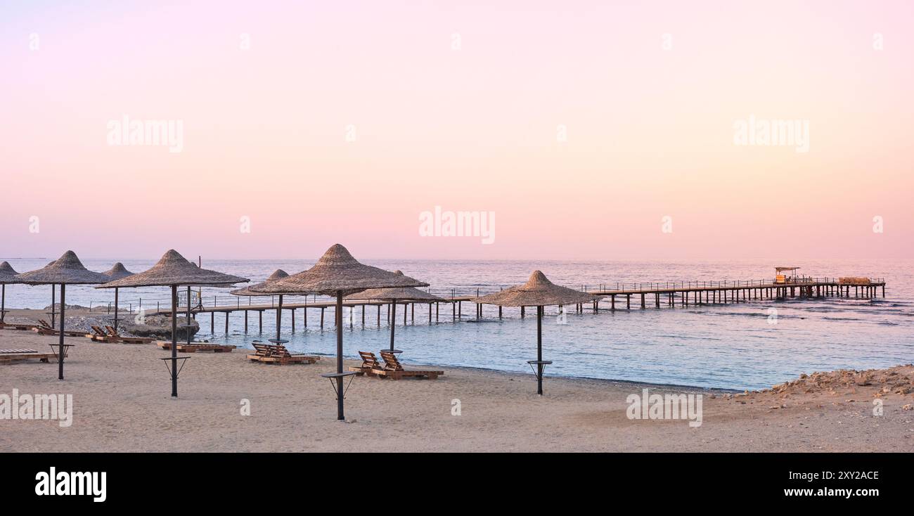 Foto di una spiaggia vuota al tramonto viola. Foto Stock