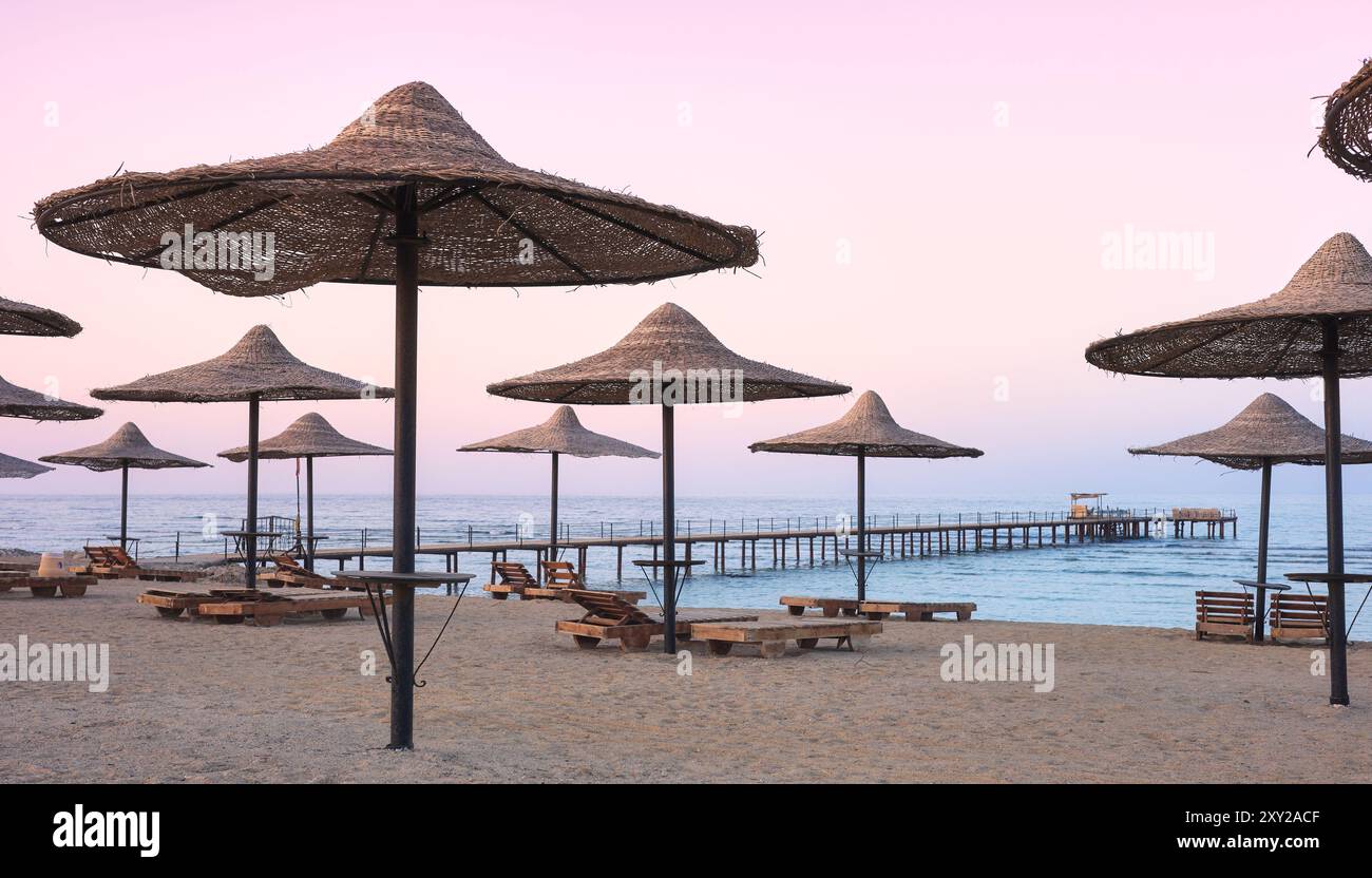 Foto di una spiaggia vuota al tramonto viola. Foto Stock