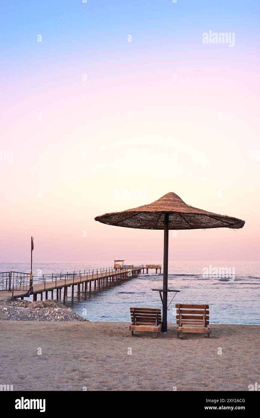 Foto di una spiaggia vuota al tramonto viola. Foto Stock