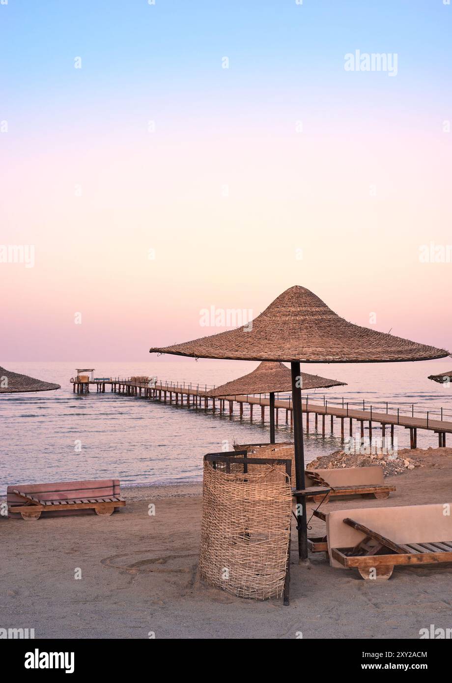 Foto di una spiaggia vuota al tramonto viola. Foto Stock