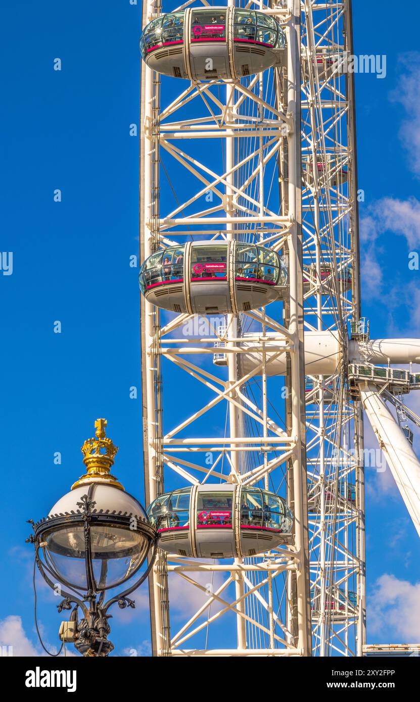 Vista laterale dal basso del London Eye o Millennium Eye, la ruota panoramica più grande e più alta del mondo, con i turisti in gondole che scattano foto a. Foto Stock