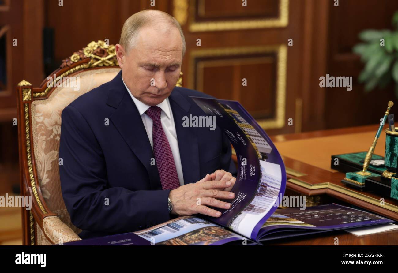 Mosca, Russia. 27 agosto 2024. Il presidente russo Vladimir Putin esamina un rapporto durante un incontro faccia a faccia con il governatore della regione di Astrakhan Igor Babushkin, al Cremlino, il 27 agosto 2024, a Mosca, in Russia. Crediti: Alexander Kazakov/piscina del Cremlino/Alamy Live News Foto Stock