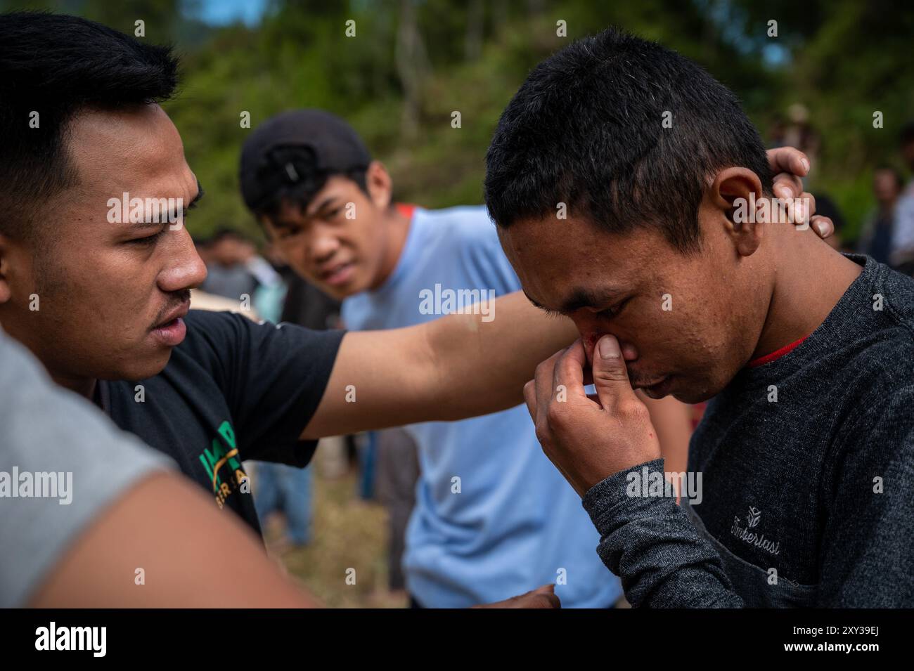 Toraja Utara, Sulawesi meridionale, Indonesia. 27 agosto 2024. Un residente si fa ferire in faccia dopo essersi preso a calci mentre tiene in mano la tradizione ''Sisemba'' (calci l'un l'altro) a Panggala, nella Reggenza di Toraja settentrionale, a sulawesi meridionale, Indonesia. Il giorno di giovedì, 27 agosto 2024. La tradizione è un'espressione di gratitudine per le colture e si basa sulla convinzione che l'evento li terrà entusiasti per il lavoro che ci attende per ottenere le prossime colture abbondanti. Senza eseguire Sisemba, la gente di Tana Toraja crede che ci sarà un fallimento del raccolto. La tradizione sostiene di sostenere i valori di parentela Foto Stock