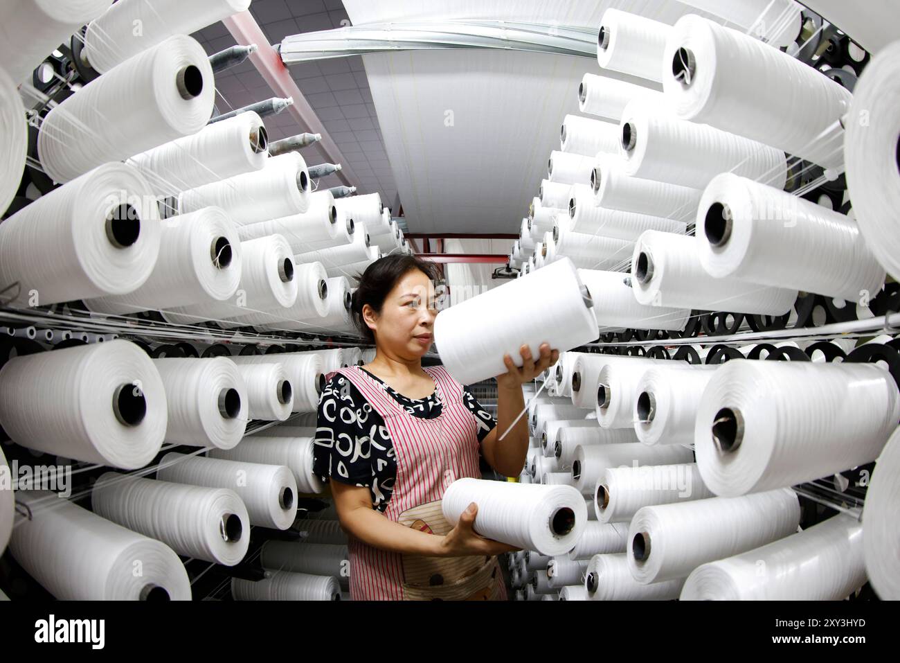 SUQIAN, CINA - 27 AGOSTO 2024 - Un lavoratore sta producendo prodotti in tessuto di plastica per l'esportazione nei paesi del sud-est asiatico in un workshop a Suqian, Jiangs Foto Stock