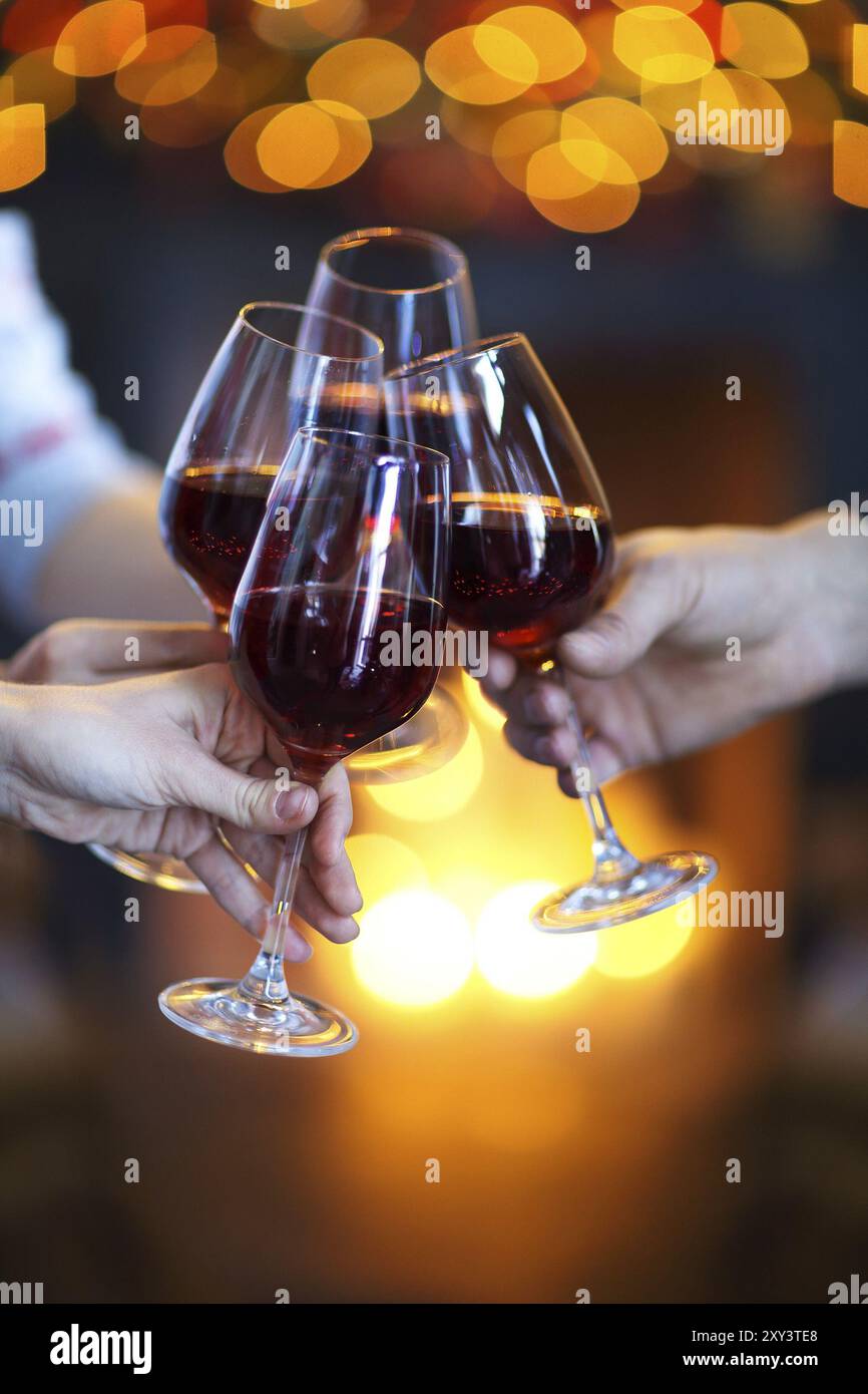 Il tintinnio di bicchieri di vino in mani su luci luminose sullo sfondo. La celebrazione di eventi Foto Stock