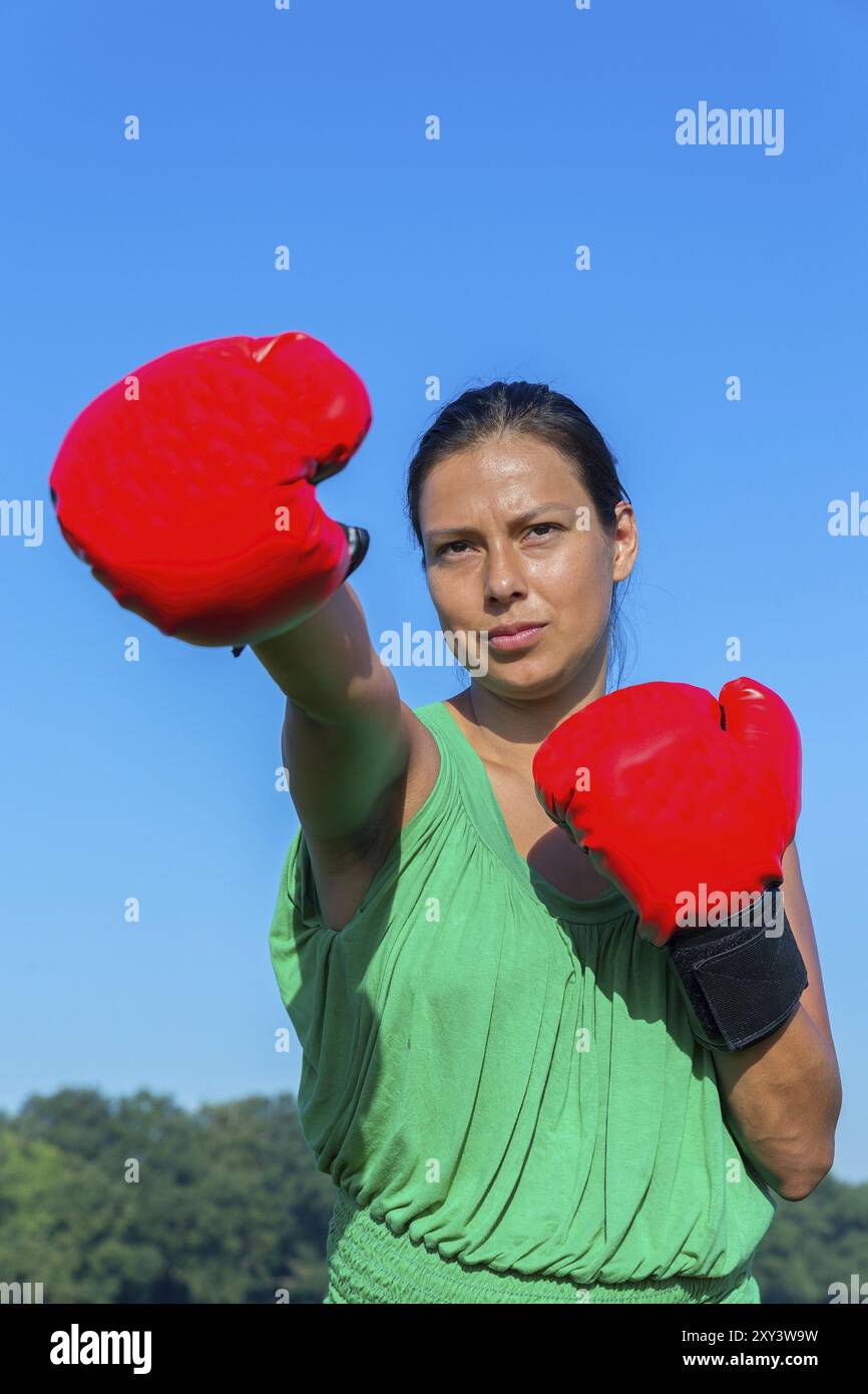 Giovanissimo colombiano donna indossa red guantoni da pugilato all'aperto Foto Stock