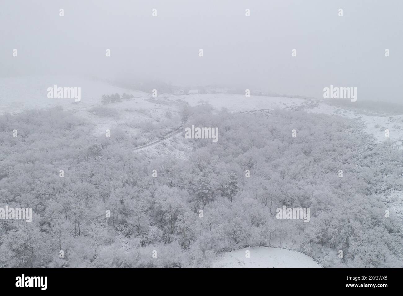 Vista aerea del drone di una strada e remoto villaggio coperto di neve nel nord del Portogallo, Vila Real Foto Stock