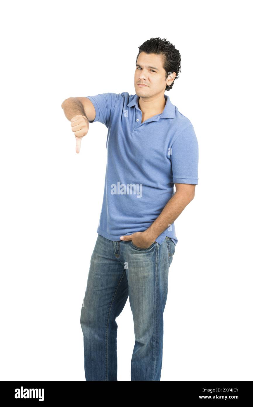 Uomo ispanico che guarda la fotocamera in abiti casual blu con espressione facciale senza emozioni, gesti con il pollice verso il basso mostrando disapprovazione, delusione, f Foto Stock