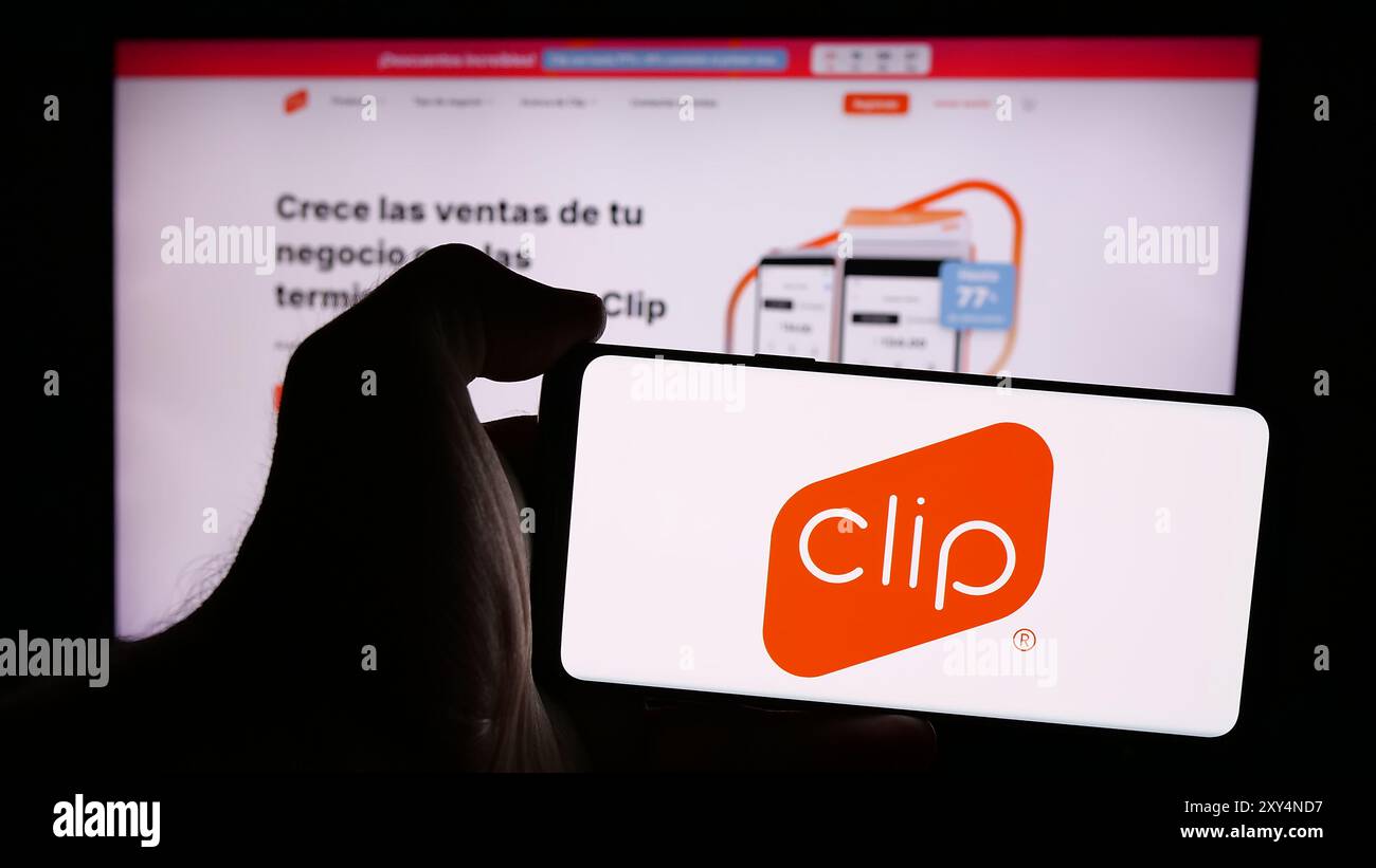 Persona che detiene un telefono cellulare con il logo della società messicana di soluzioni di pagamento PayClip Inc. (Clip.mx) di fronte alla pagina Web. Mettere a fuoco il display del telefono. Foto Stock