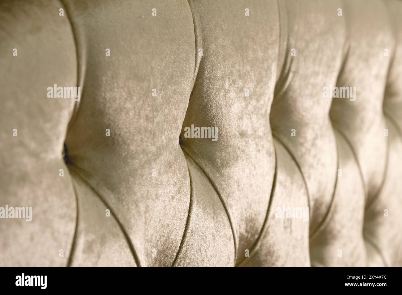 Fondo in morbido tessuto beige con bottoni simmetrici sugli angoli dei diamanti. Elementi mobili morbidi e costosi. Sfondo di lusso Foto Stock