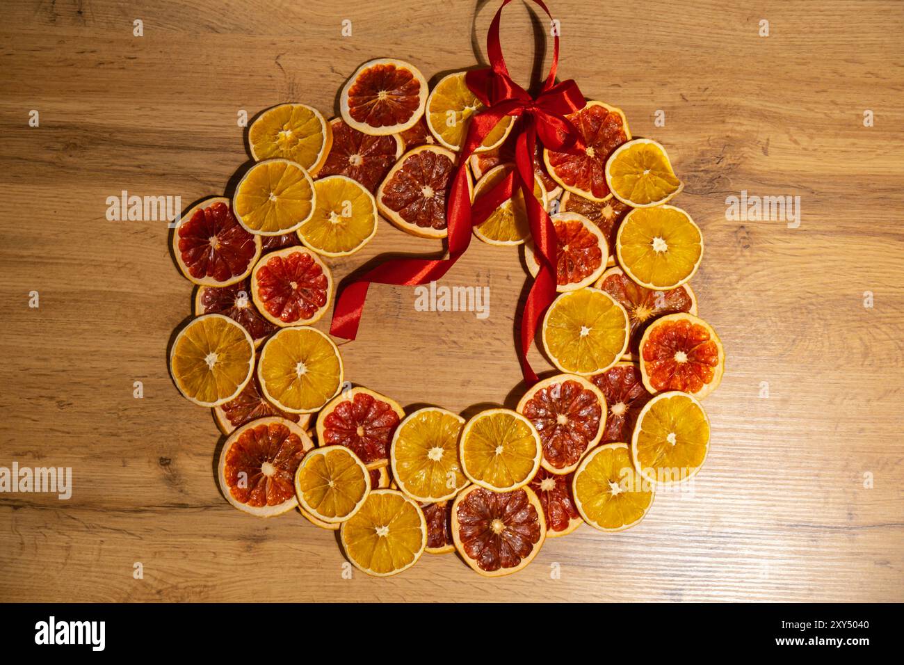 Fase 4 processo fai-da-te di una donna che prepara un accordo natalizio con arance secche e pompelmo. Serie di istruzioni artigianali. Decorazioni ecologiche per le vacanze invernali a zero sprechi. Anno nuovo Foto Stock