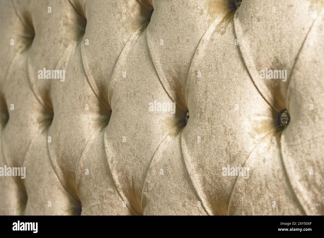 Fondo in morbido tessuto beige con bottoni simmetrici sugli angoli dei diamanti. Elementi mobili morbidi e costosi. Sfondo di lusso Foto Stock