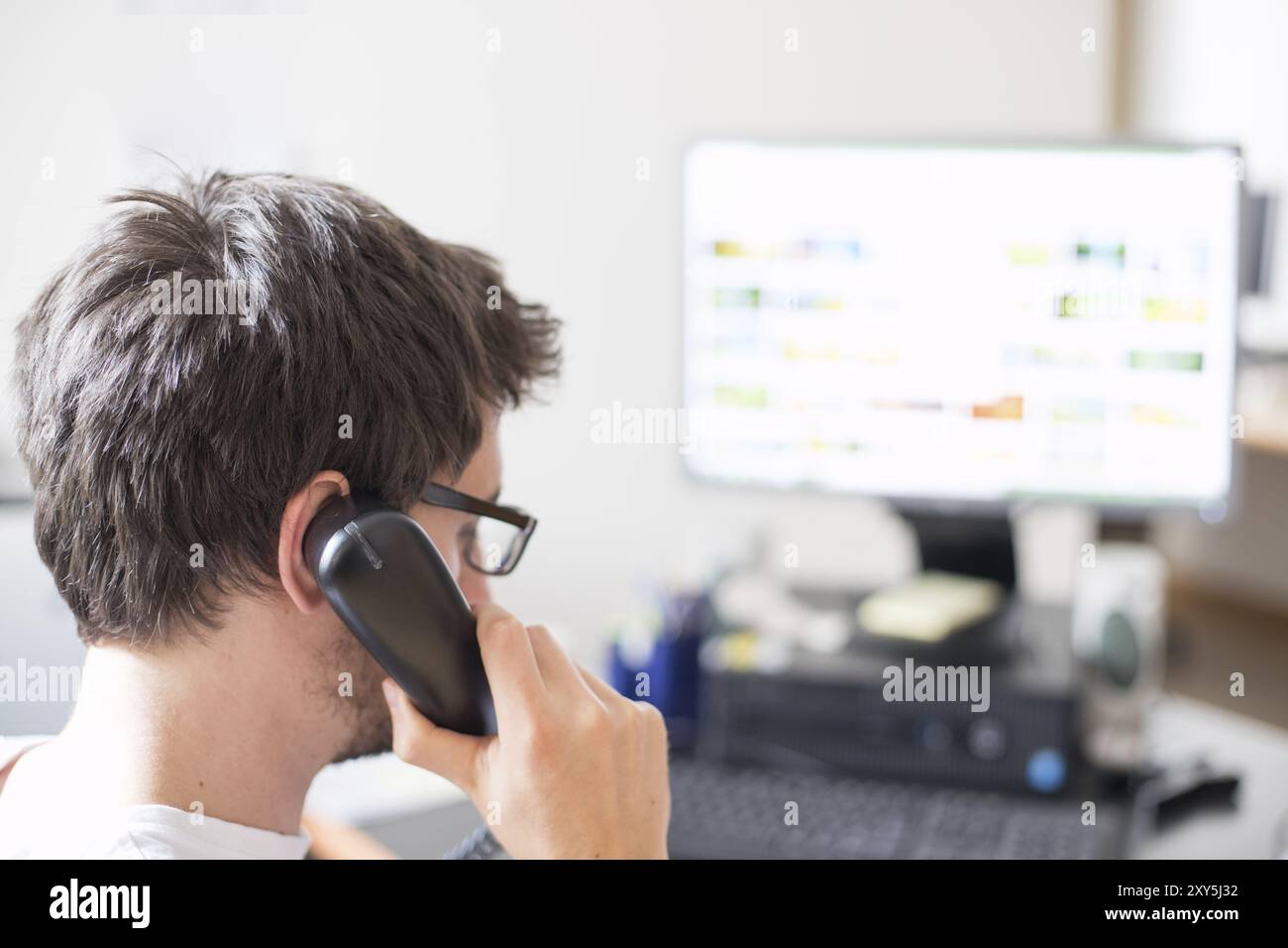 Il dipendente sta parlando al telefono con i clienti Foto Stock