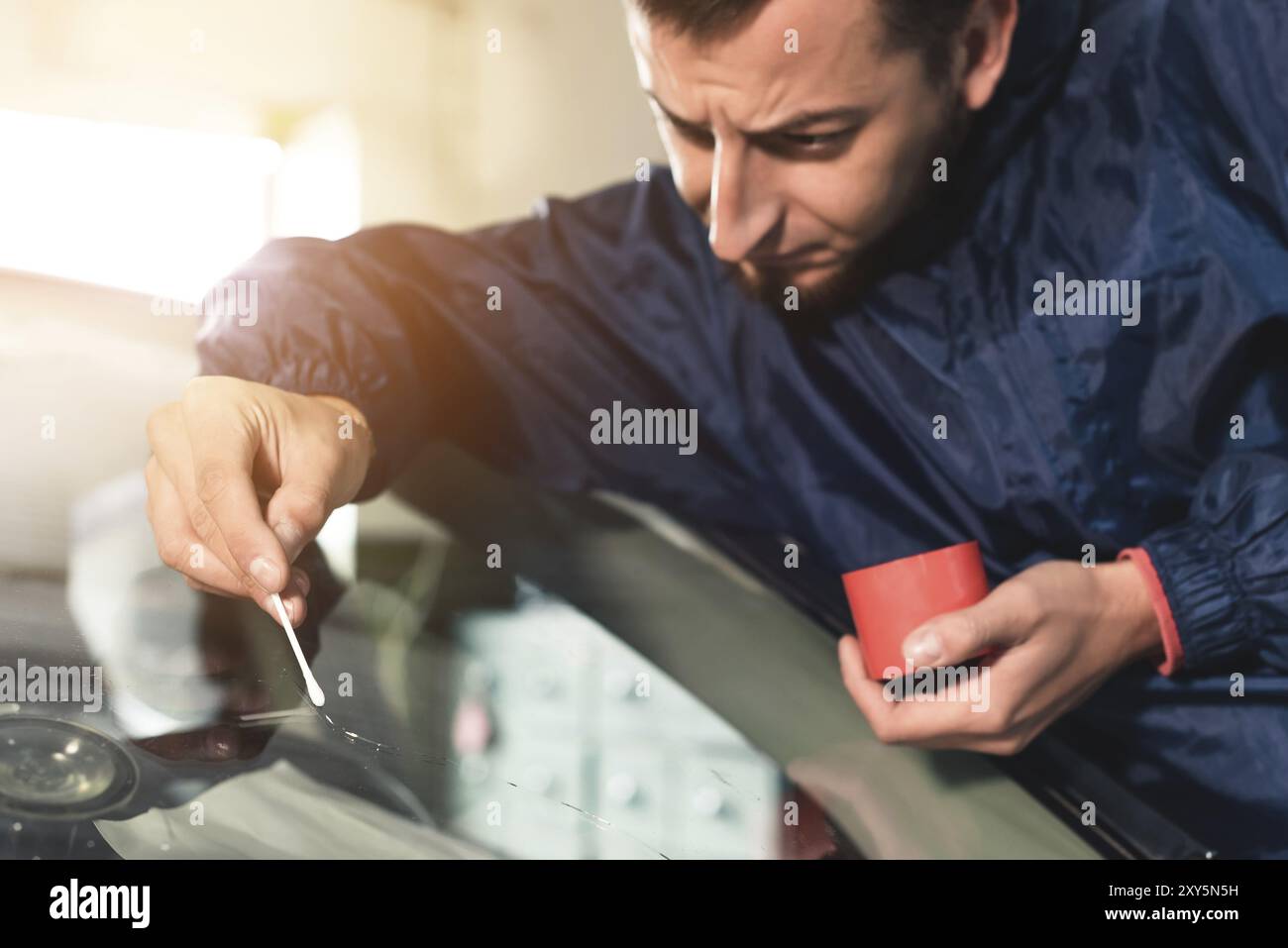 Primo piano lavoratore di glazier Automobile fissaggio e riparazione parabrezza o parabrezza di un'auto in garage stazione di servizio auto Foto Stock