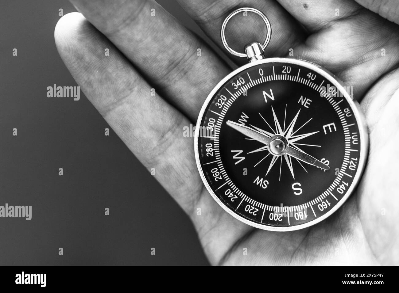 Primo piano di un mans mano che tiene una bussola nella sua mano. Concetto per il business, per l'innovazione Foto Stock