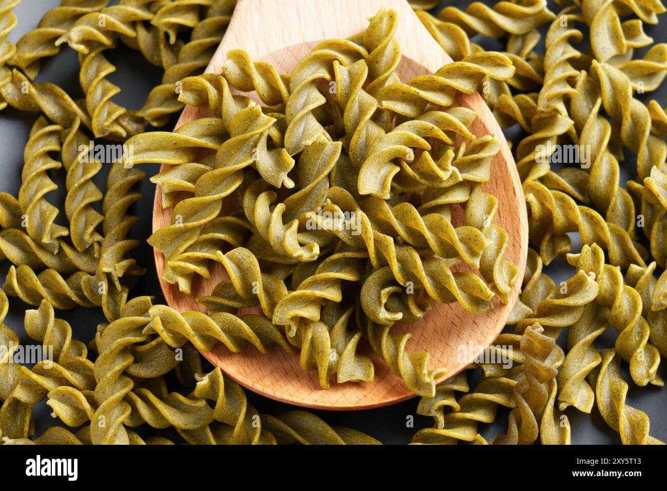 Fusilli dietetici a spirale di piselli con aggiunta di alghe wakame in cucchiaio di legno per una dieta senza glutine. Vista dall'alto dei maccheroni organici. Foto Stock