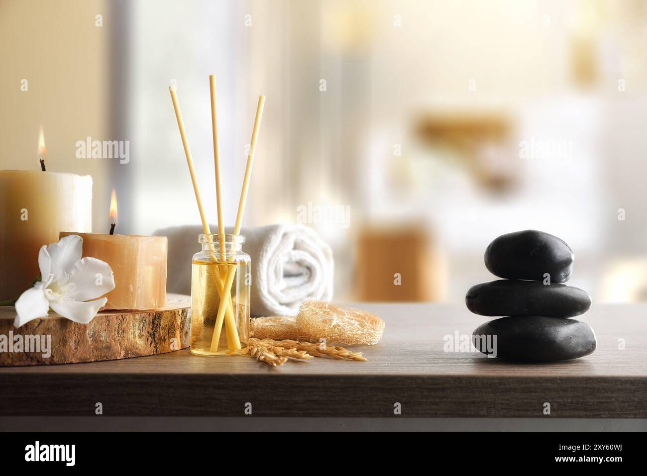 Benessere del corpo e aromaterapia con prodotti su un tavolo con candele ed elementi decorativi e camera sullo sfondo. Foto Stock