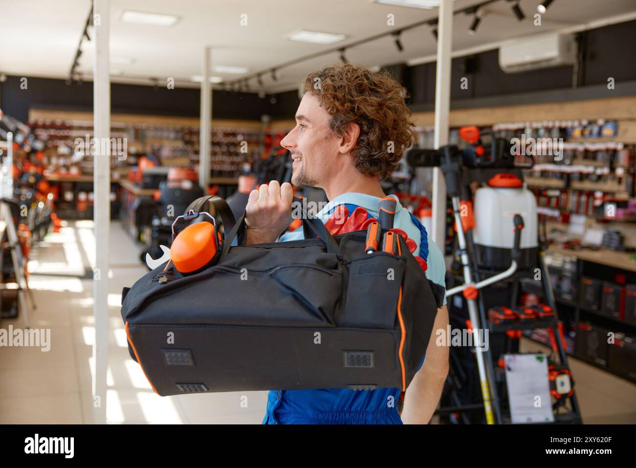 I riparatori camminano con i moderni utensili riempiti di sacchetti presso il negozio di ferramenta Foto Stock