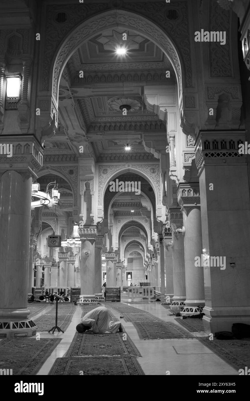 Uomo musulmano non identificato in posizione di prostrazione durante la sessione di preghiera all'interno della Sacra Moschea di Haram in Mecca, Arabia Saudita. Foto Stock