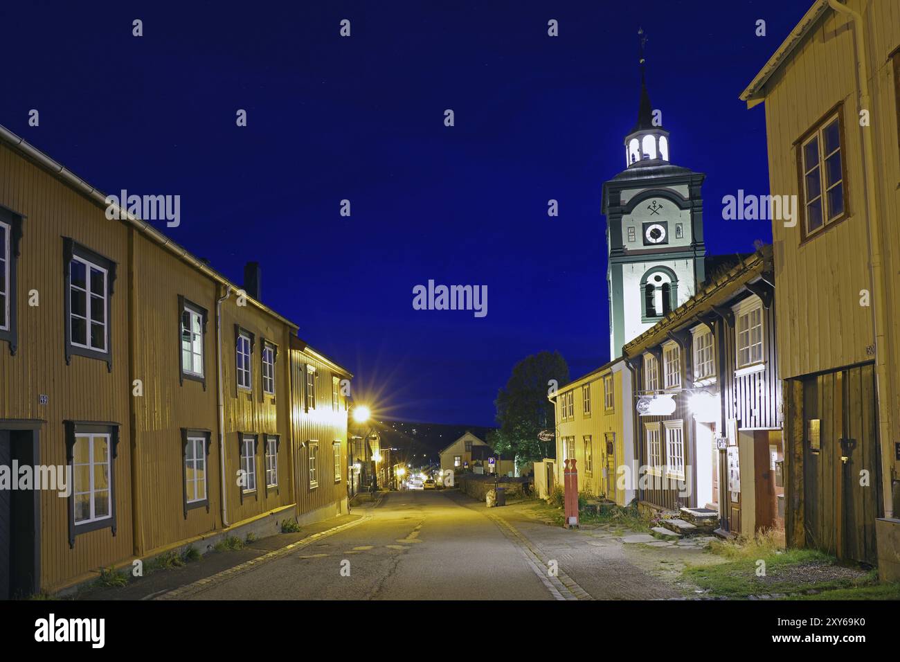 Vista sulla strada di una città tradizionale di notte con edifici antichi illuminati e una torre della chiesa, la chiesa dei minatori, sito patrimonio dell'umanità dell'UNESCO, città dei minatori Foto Stock