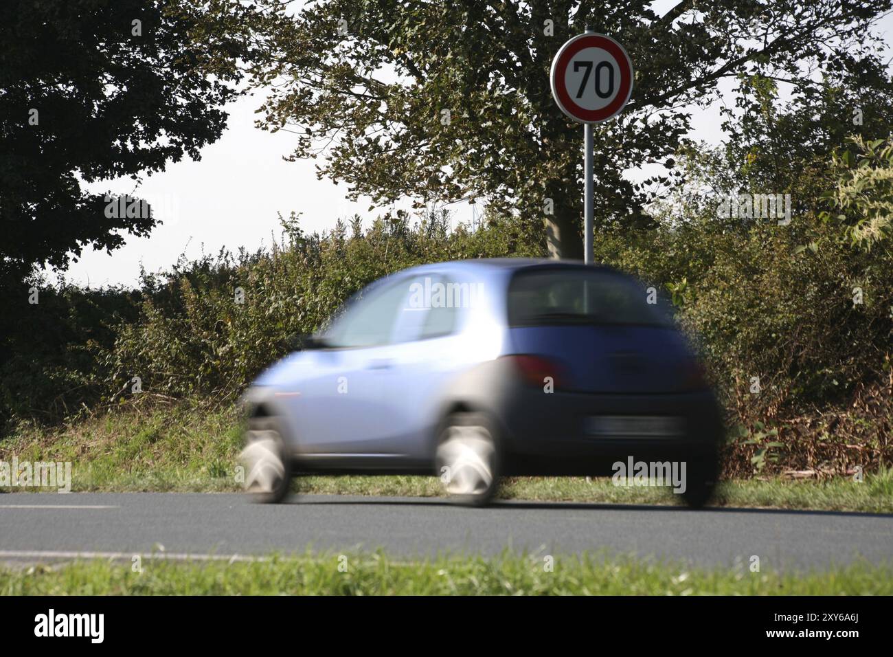 Velocità in corso davanti a un cartello di 70 km/h. Foto Stock